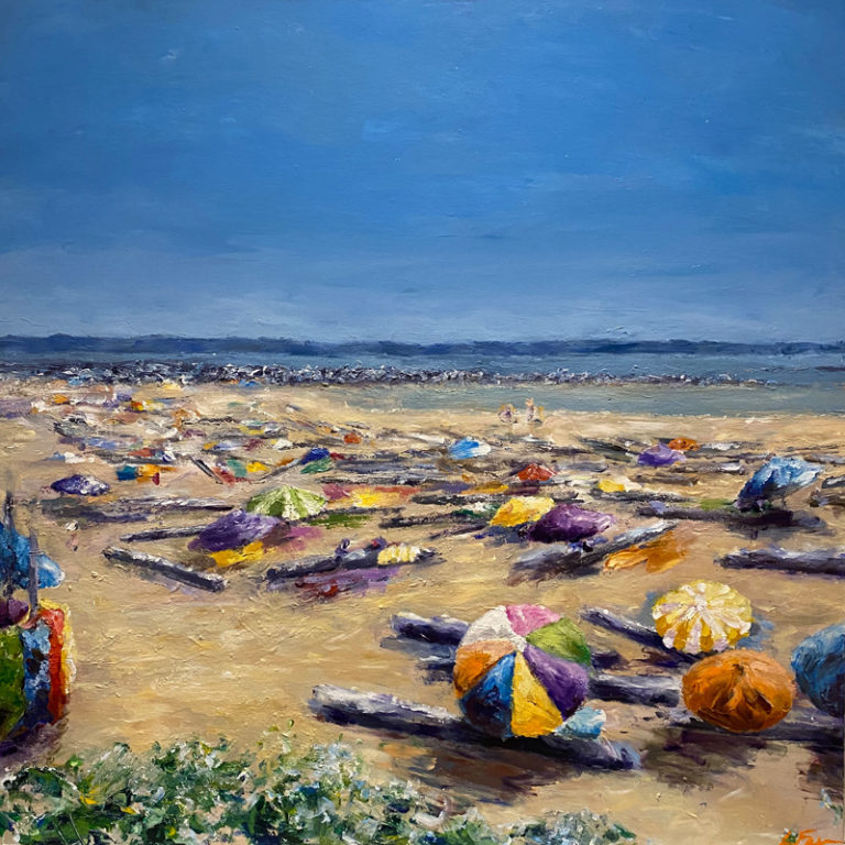 A stretch of ochre peppered with colourful umbrellas meets a horizontal strip of blue ocean under a clear blue sky.